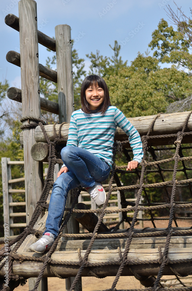 公園の遊具で遊ぶ女の子