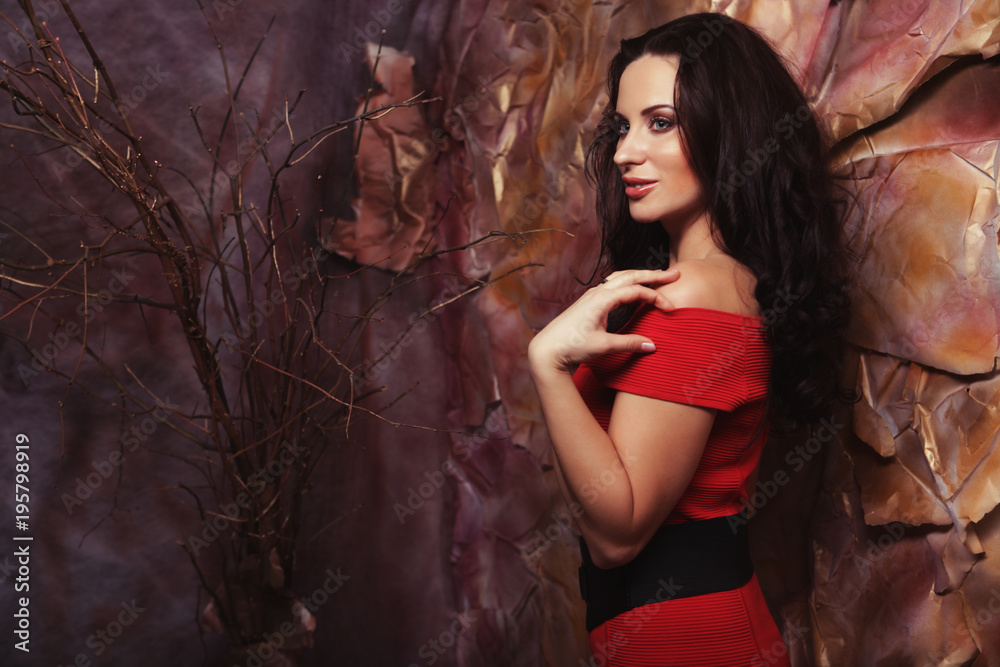 Obraz premium Sensual beautiful brunette woman posing in red dress. Art and fa