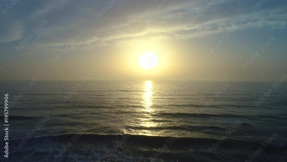 Aerial drone view of beautiful sunrise over the sea water and beach Aerial drone view of beautiful sunrise over the sea water and beach