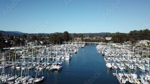 Aerial flyby of boats docked in a Pacific harbor photo