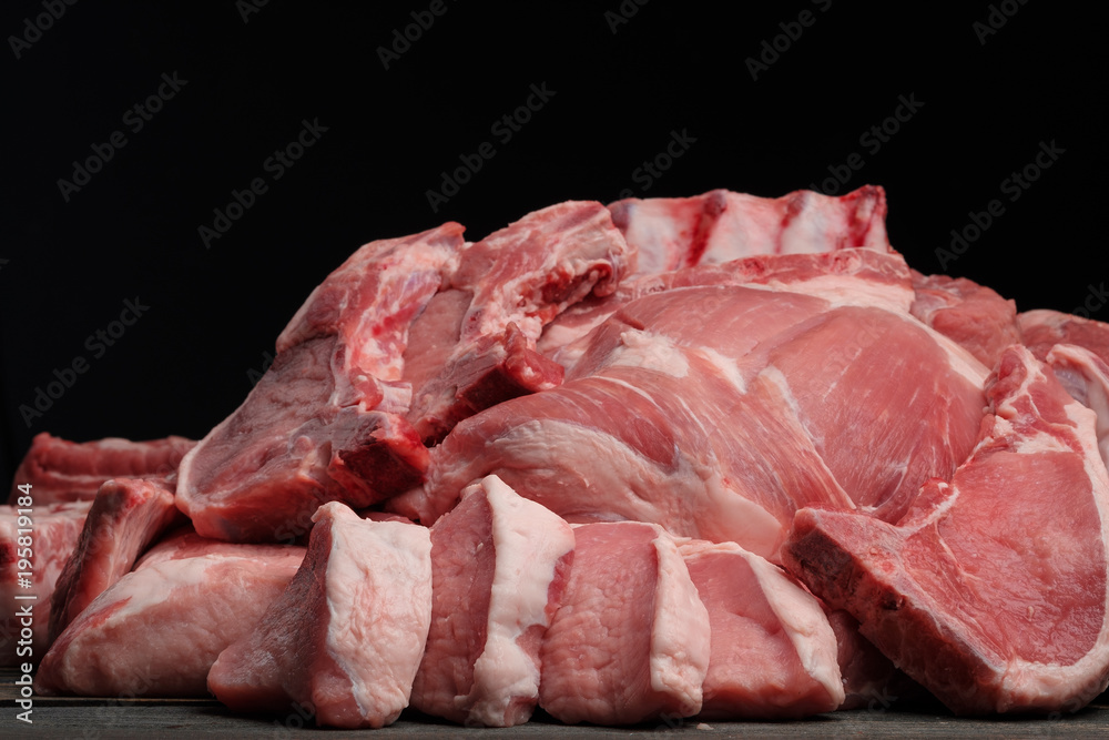 Assorted raw meat on a wooden dark background. Front veiw Assorted raw meat on a wooden dark background. Front veiw