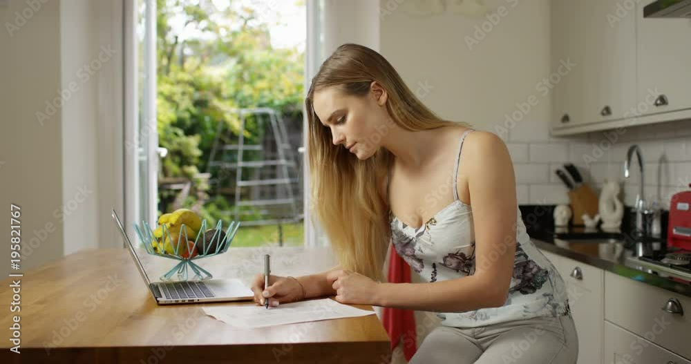 4K Beautiful woman working at the kitchen table, young businesswoman or student. Slow motion.
