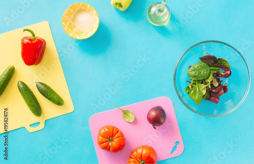 Frame from ingredients for cooking summer salad on blue background, top view. Healthy food concept. Diet food