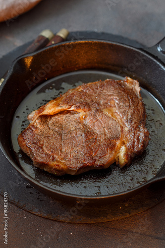 Close up juicy beef steak on vintage cast iron frying pan