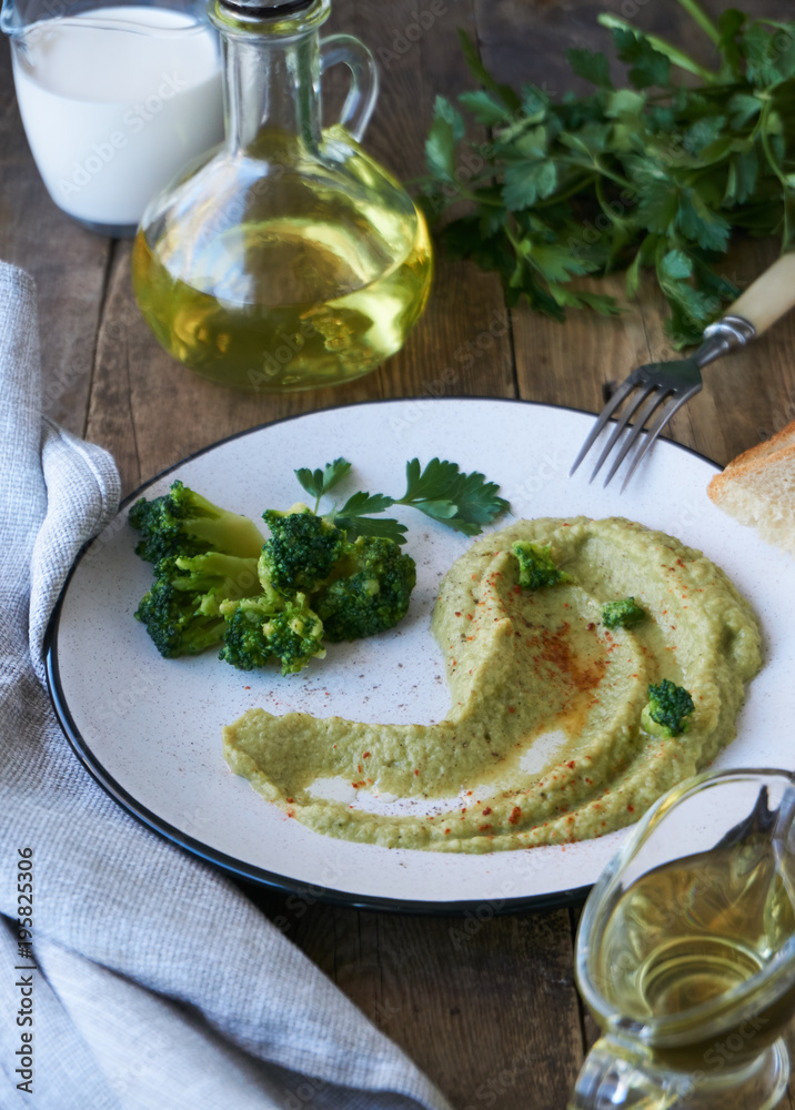 Broccoli puree in a plate on a wooden table Broccoli puree in a plate on a wooden table