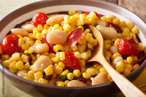 Salad succotash of oil beans, tomatoes, peppers and bacon macro in a bowl. horizontal
