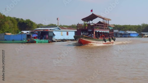 View of houses of floating village and boats with tourists