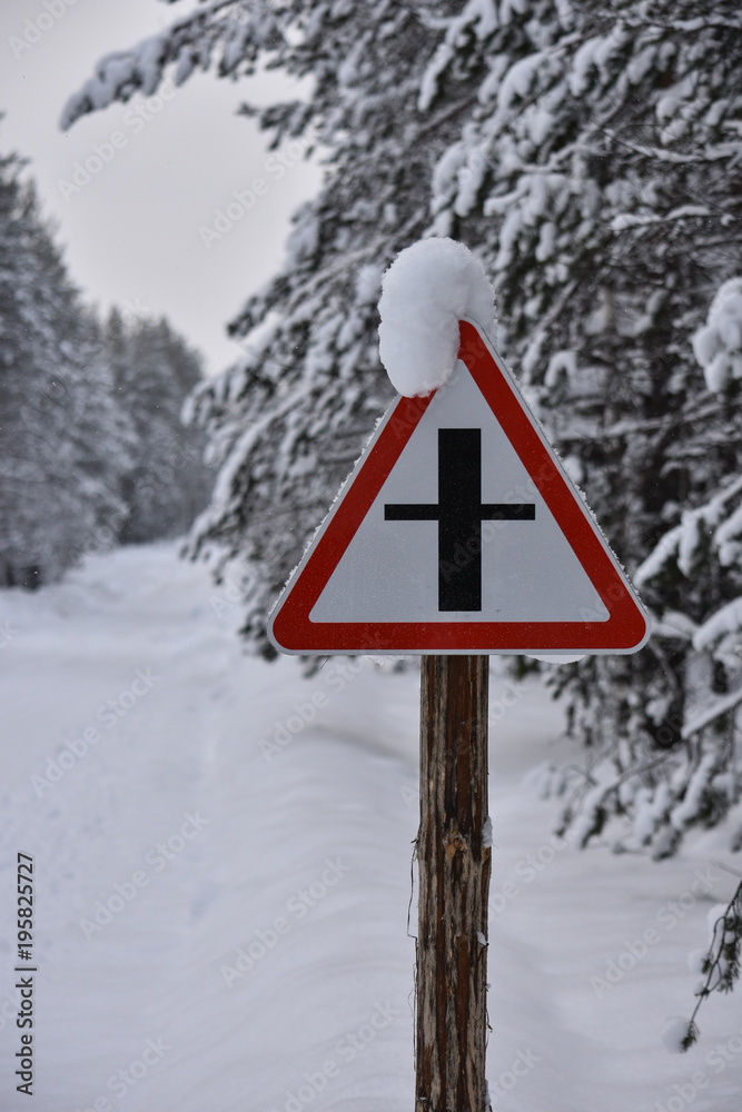 Warning road sign on a snowy winter forest road Warning road sign on a snowy winter forest road