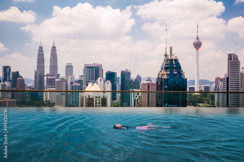 Photography Asian girl swimming in roof top swimming pool in hotel