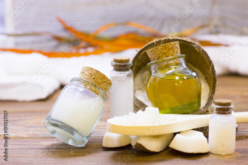 Natural herbal skin care products, top view ingredients coconut, white and yellow bottles with oil on table concept of the best all natural face moisturizer. Facial treatment preparation background
