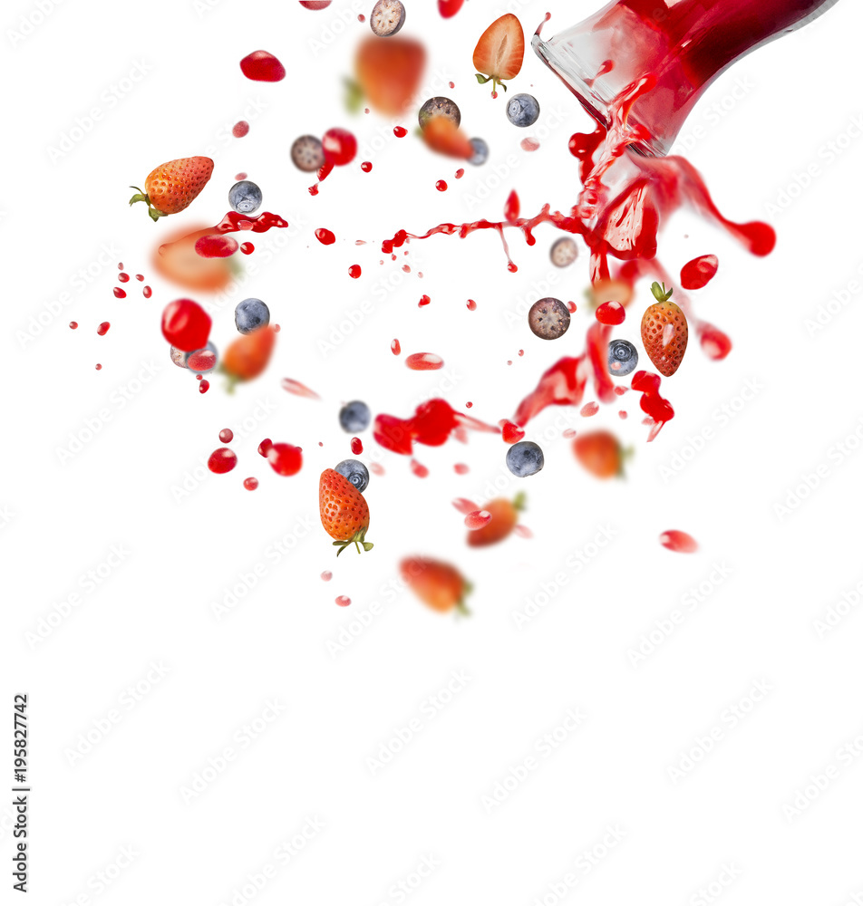 Red juice or smoothie drink is poured out of glass bottle with splash and berries ingredients,  isolated on white background, front view. Healthy summer beverage concept