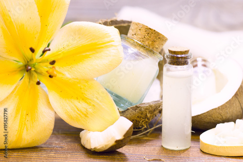 Natural herbal skin care products, top view ingredients coconut, lily flower, essence oil on table concept of the best all natural face moisturizer. Facial treatment preparation background