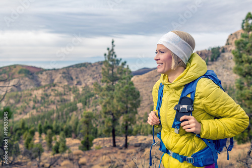 Hiking woman with backpack looking at inspirational mountains landscape