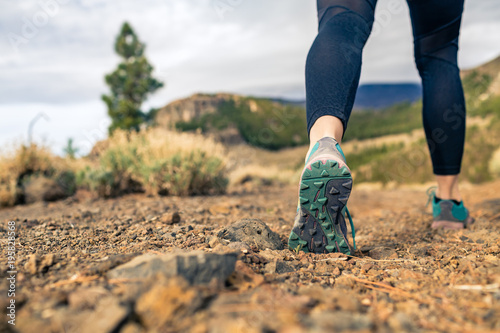 Sole of shoe walking in mountains on rocky footpath