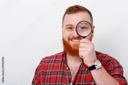man looking at magnifying glass