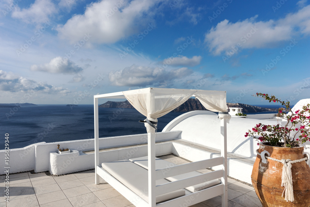 Fototapeta premium Relaxation zone on the terrace with sunbeds in Oia, Santorini