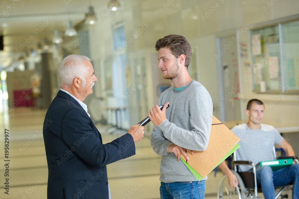 Fototapeta premium male teacher in a school corridor with student