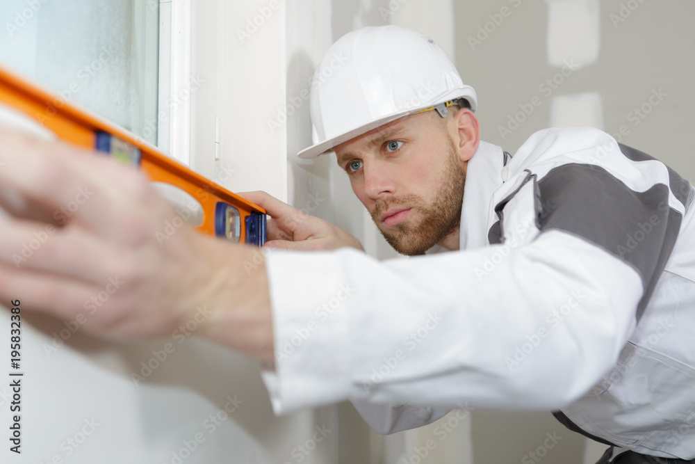 young man viewing a spirit level young man viewing a spirit level
