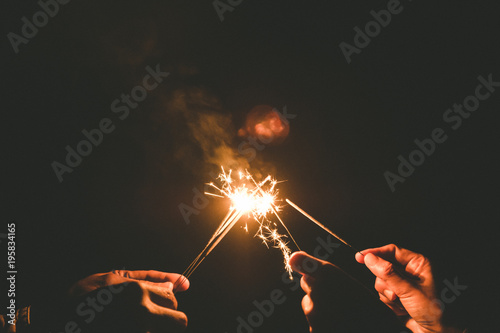 Closeup image of hands holding sparklers for celebrate in the night time