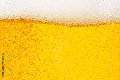Pouring beer with bubble froth in glass for background on front view wave curve shape