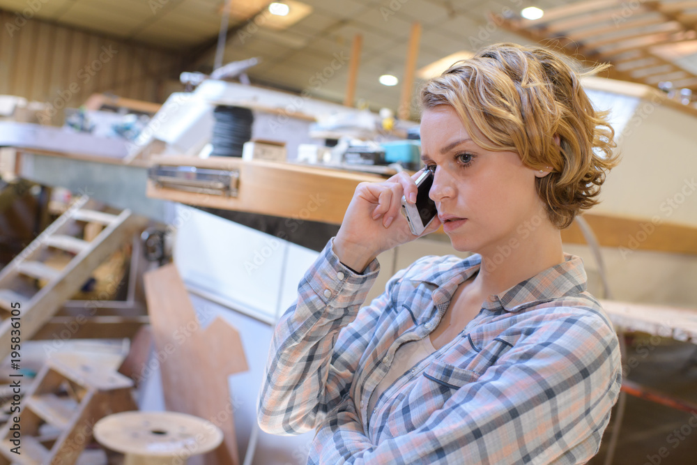 young woman on the phone in marine workshop young woman on the phone in marine workshop