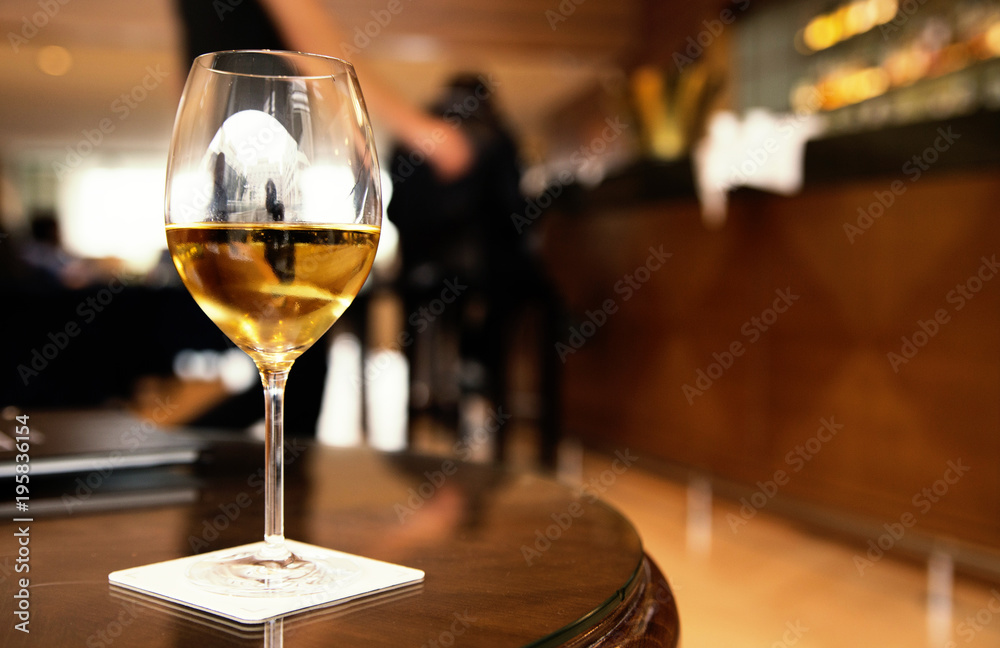 a glass of white wine on a table