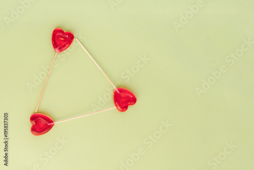 A composition of heart-shaped lollipops about relationships in a love triangle