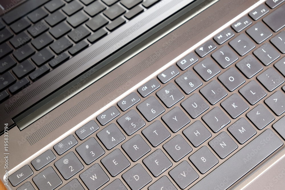 Part of opened laptop with keyboard, touchpad and empty mirror screen of black opened laptop top view closeup