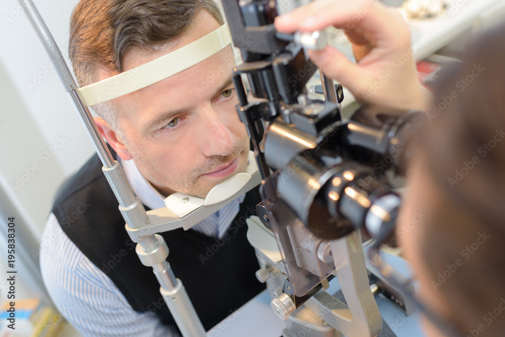 Φωτογραφία optician checking patient's eyes