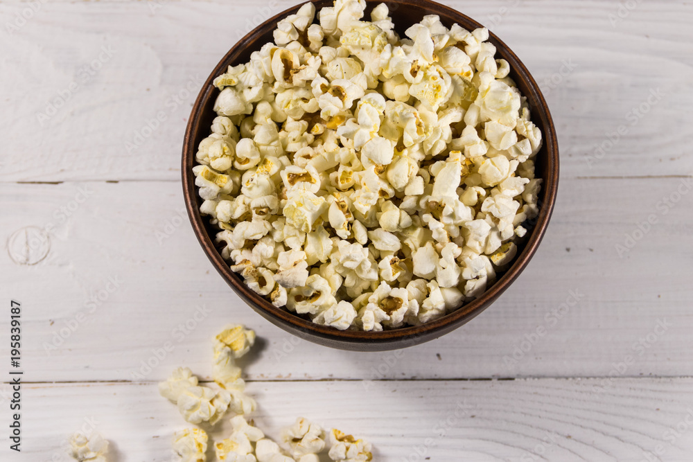 Bowl with popcorn on wooden table Bowl with popcorn on wooden table