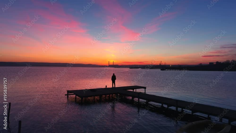 Aerial drone flight over small dock and boat at the lake, beautiful sunrise view Aerial drone flight over small dock and boat at the lake, beautiful sunrise view