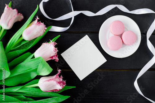 Tulips and macaroons wooden background photo