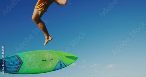 Kitesurfing at sunset in slow motion, kiteboarder gets big air