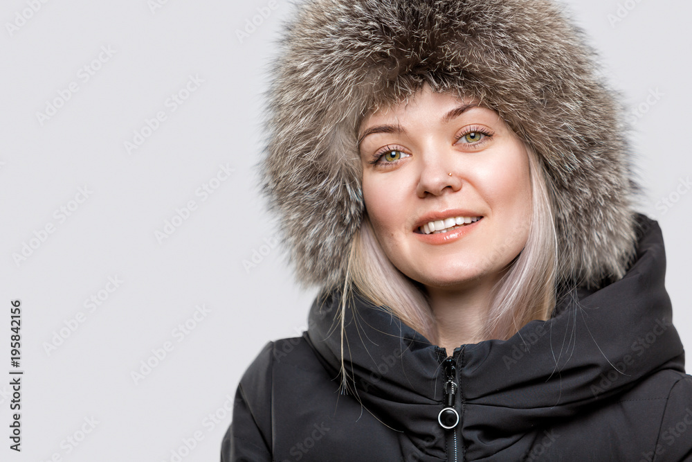 Portrait of a beautiful young woman in a trendy fur hat. Headdress. Female face closeup Portrait of a beautiful young woman in a trendy fur hat. Headdress. Female face closeup