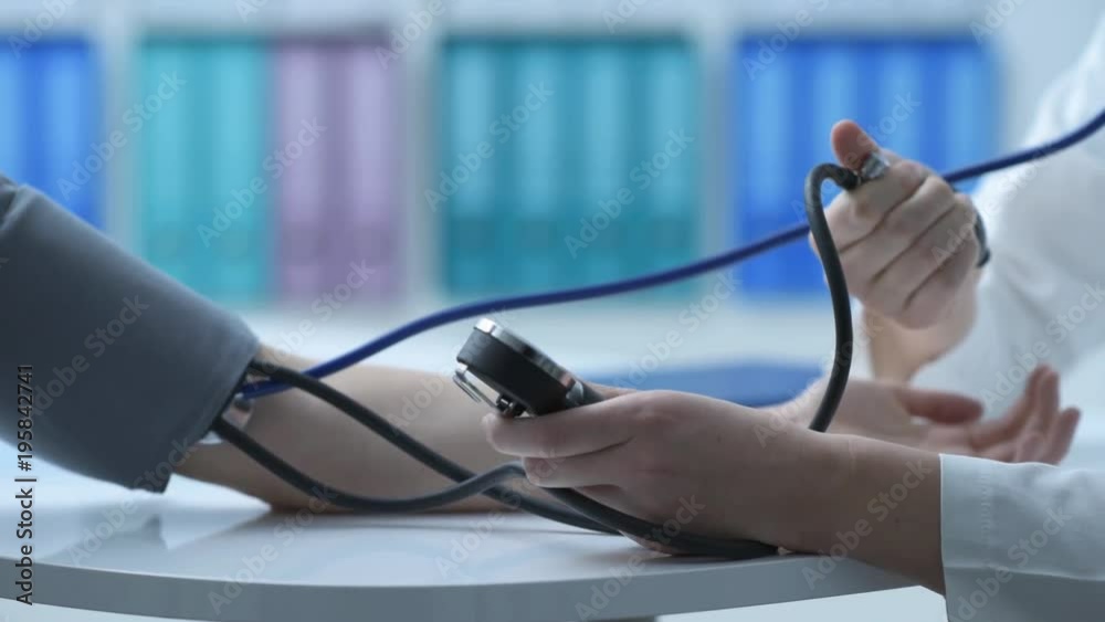 Doctor measuring a patient's blood pressure Doctor measuring a patient's blood pressure