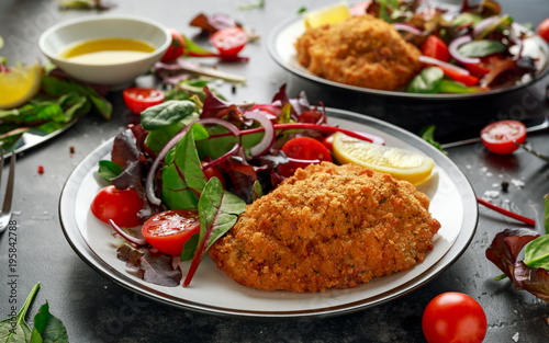 Fototapeta Naklejka Na Ścianę i Meble -  Breaded Chicken Kiev breast stuffed with butter, garlic and herbs served with vegetables in a plate.