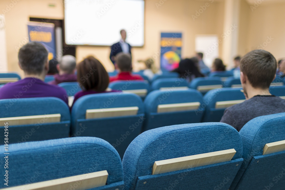 Business Meetings Ideas and Concepts. Male Presenter Giving a Talk in Front of a Small Group Of Listeneres on a Conference.