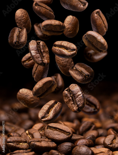 Falling coffee beans. Dark background with copy space