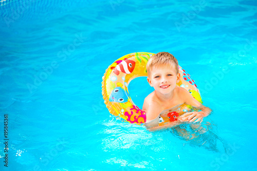 Boy floating on an inflatable circle in the pool