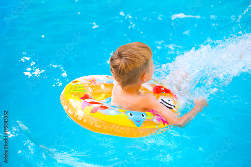 Boy floating on an inflatable circle in the pool