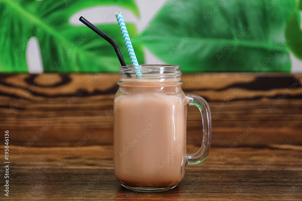 Mason jar with protein shake on table in sport bar