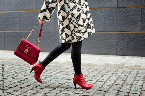 Stylish woman in red shoes walking down the street