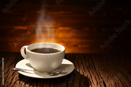 Cup of coffee with smoke on old wooden background