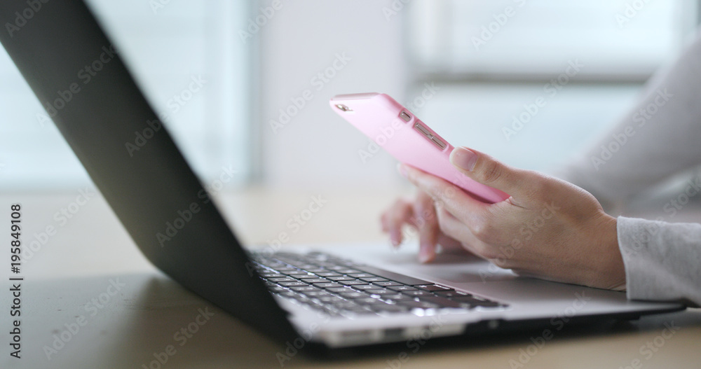 Woman working on laptop computer and use of cellphone Woman working on laptop computer and use of cellphone