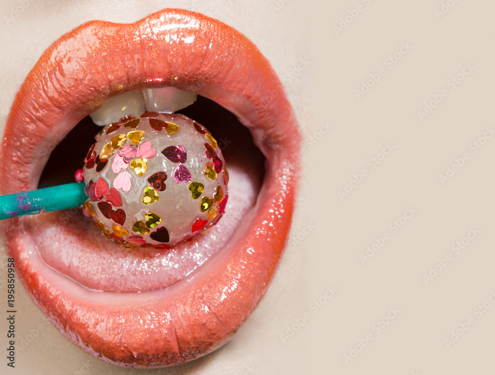 Sexy tasty tongue. Open female mouth with candy inside. Lollipop covered  little hearts. Pink lipstick on