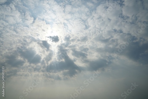 Blue sky background with white clouds and sun ray © wanchanta