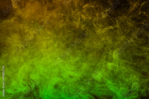 Green and yellow smoke texture on a black background. Texture and abstract art