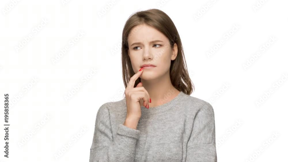 Portrait of hesitating woman holding finger on lips meaning dont know or weighing pros and cons, over white background with doubtful expressions. Concept of emotions Portrait of hesitating woman holding finger on lips meaning dont know or weighing pros and cons, over white background with doubtful expressions. Concept of emotions