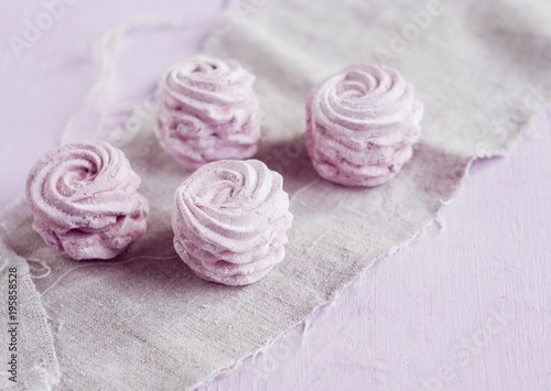Blueberry marshmallow on gray napkin over pink background.