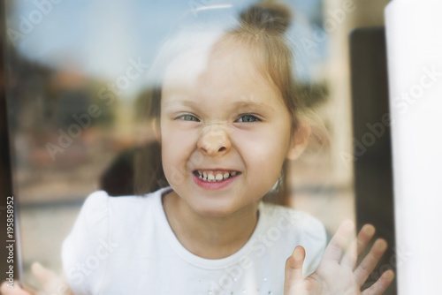 Little girl show emotions in window